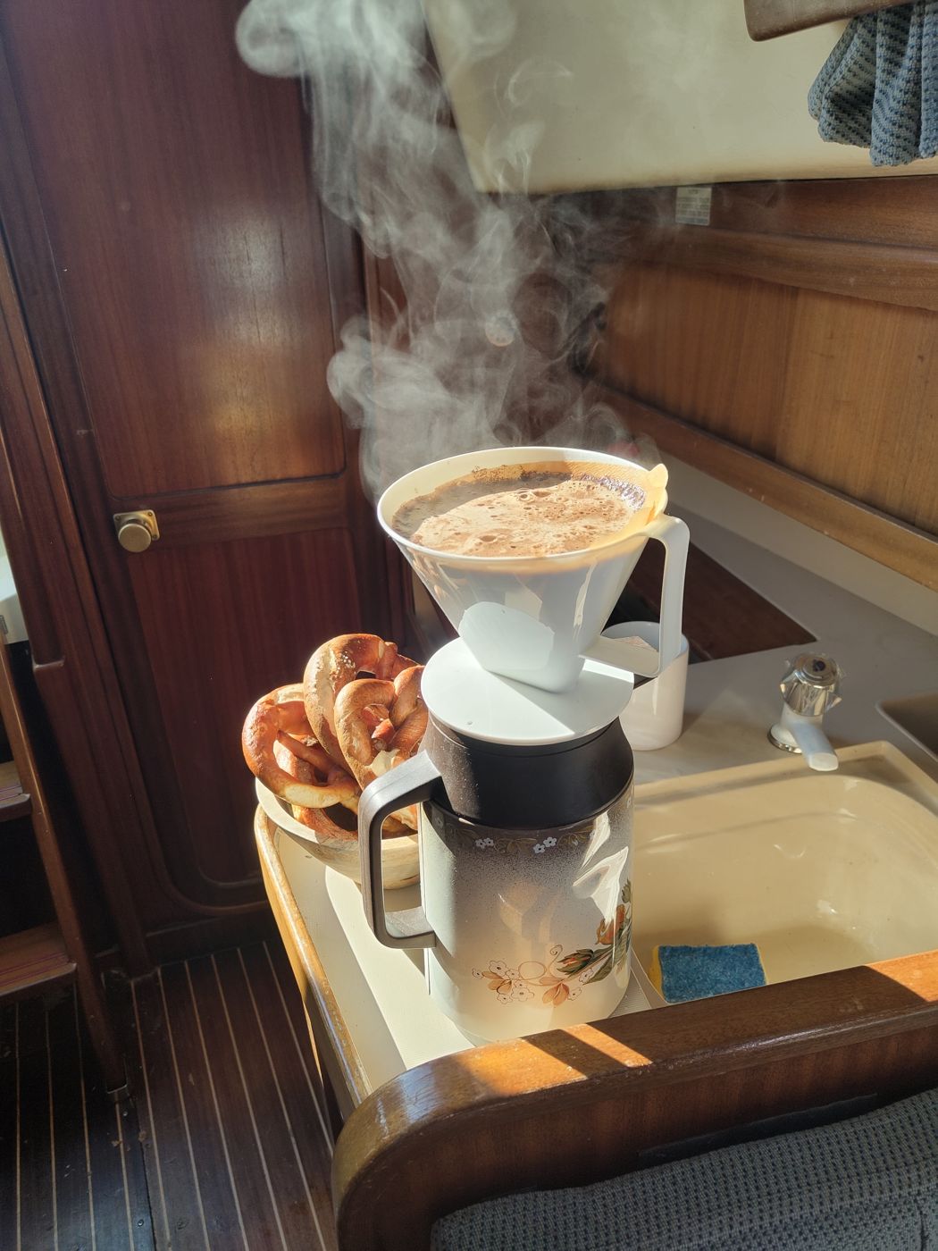 Dampfender Filterkaffee und Brezeln in einer kleinen Bootsküche